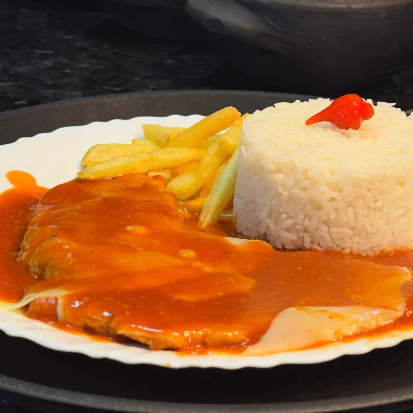 Filé de frango ao molho com queijo derretido, arroz e batata frita no Flavia's Restaurante