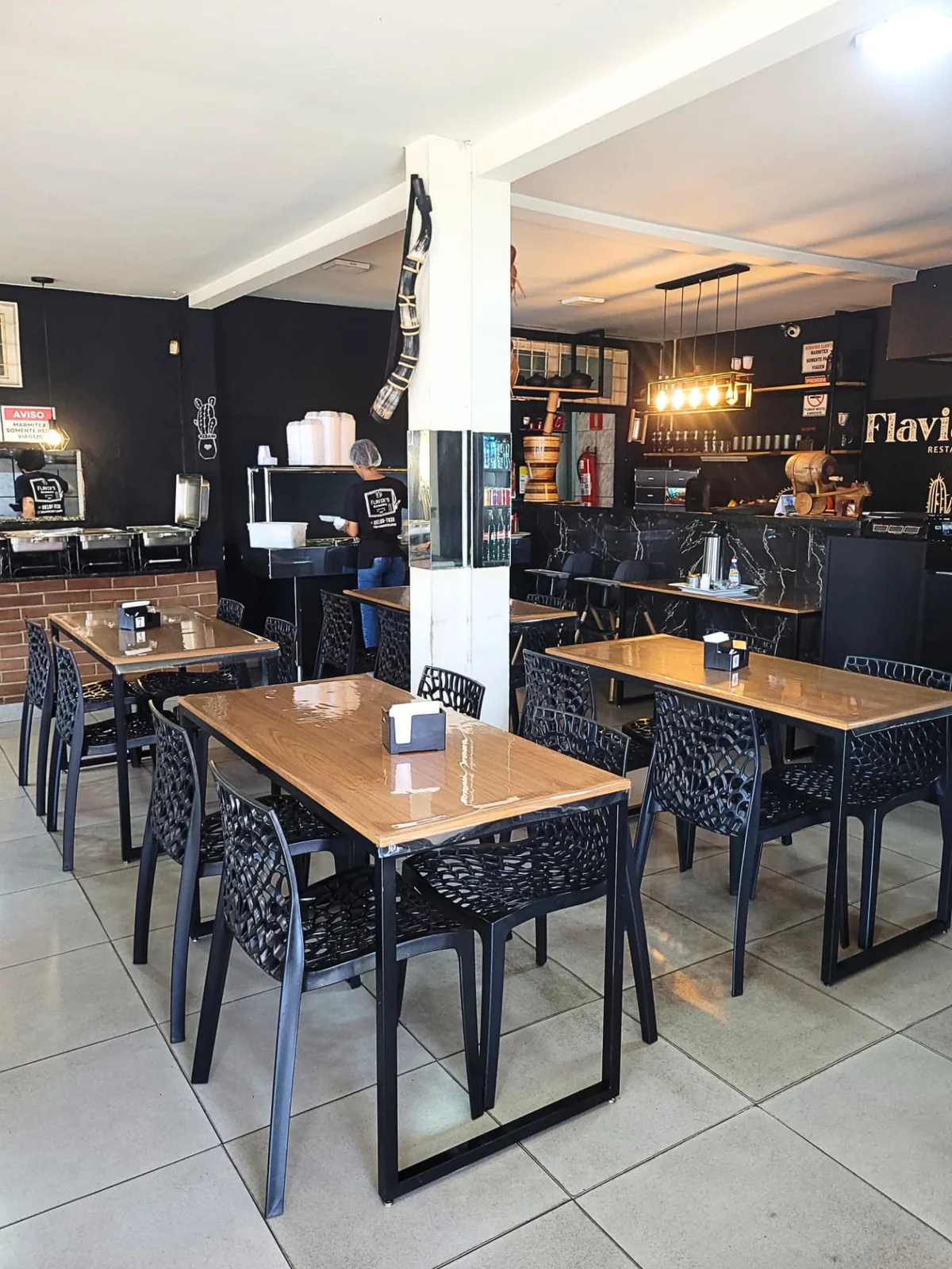 Interior do Flavia's Restaurante com mesas organizadas e salão familiar em Campo Grande
