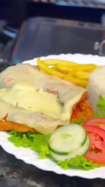 Filé à parmegiana com arroz, batata frita e salada servido no almoço em Campo Grande